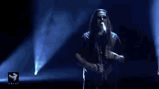 a blue light is coming from a person in a dark room
