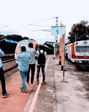 people standing on a train platform with a sign that says 1 on it