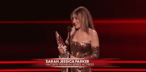 sarah jessica parker is holding a trophy and smiling while speaking into a microphone