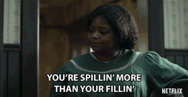 a woman in a green dress is saying " you 're spillin ' more than your fillin ' "