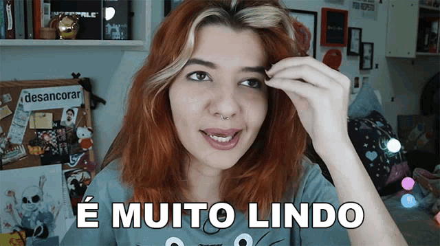 a woman with red hair and the words e muito lindo on her shirt