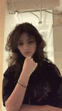 a girl with a ring on her finger is wearing a black t-shirt with a flame on the sleeve