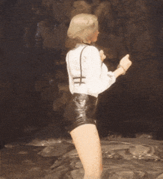 a woman in a white shirt and black shorts is giving a thumbs up