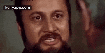a close up of a man 's face with a beard and the words kulfyapp.com in the corner
