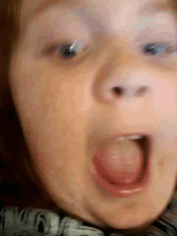 a close up of a woman 's face with her tongue sticking out