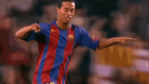 a soccer player is pointing at another player while wearing a striped shirt .