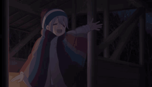 a girl with pink hair and a striped jacket stands in the dark