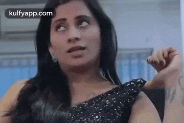 a woman in a black dress is making a funny face and looking up .