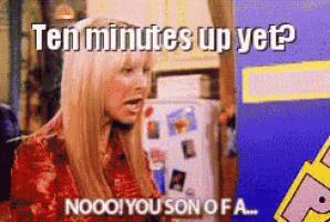 a woman sitting in front of a refrigerator with the words ten minutes up yet written on it