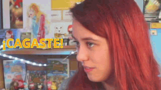 a woman with red hair is standing in front of a shelf with a sign that says cagaste