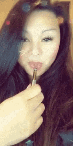 a woman is smoking an electronic cigarette and has a cat face painted on her face