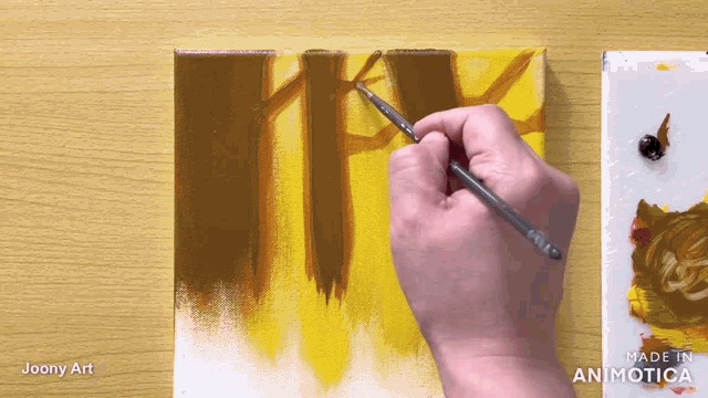 a person is painting on a canvas with a made in animatica logo