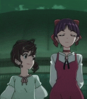 a couple of anime girls are standing next to each other .