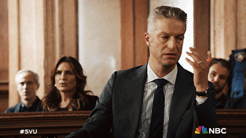 a man in a suit and tie is giving a speech in front of nbc