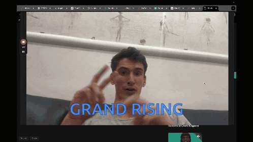 a man giving a peace sign in front of a screen that says " grand rising "