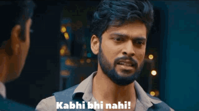 a man with a beard is talking to another man and says kabhi bhi nahi !