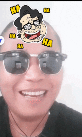 a man wearing sunglasses has a sticker on his face that says ha on it