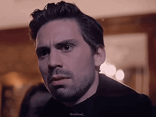 a close up of a man 's face with a beard and a black shirt with the hashtag @callined_ on it