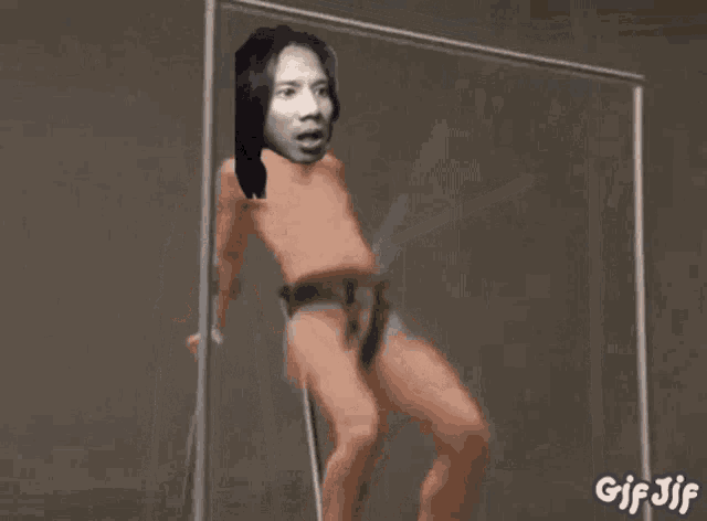 a shirtless man is looking at himself in the mirror .