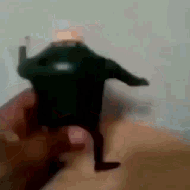 a person is holding a toy in their hand that looks like a person with a lighter in their hand .