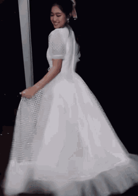 a woman in a long white dress is smiling