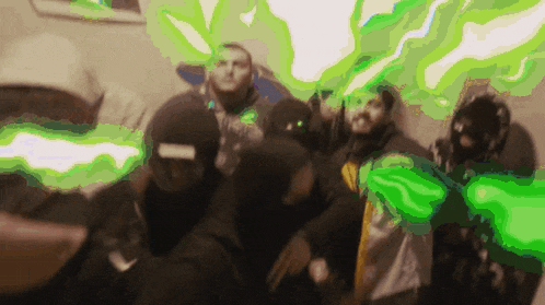 a group of people are posing for a picture with green smoke coming out of their heads .