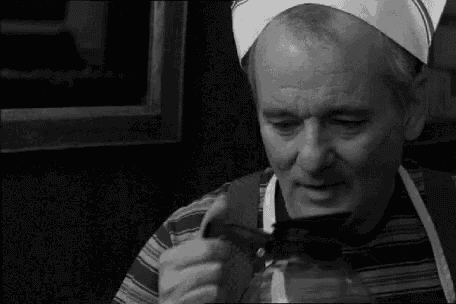a man in a chef 's hat is drinking from a coffee pot .