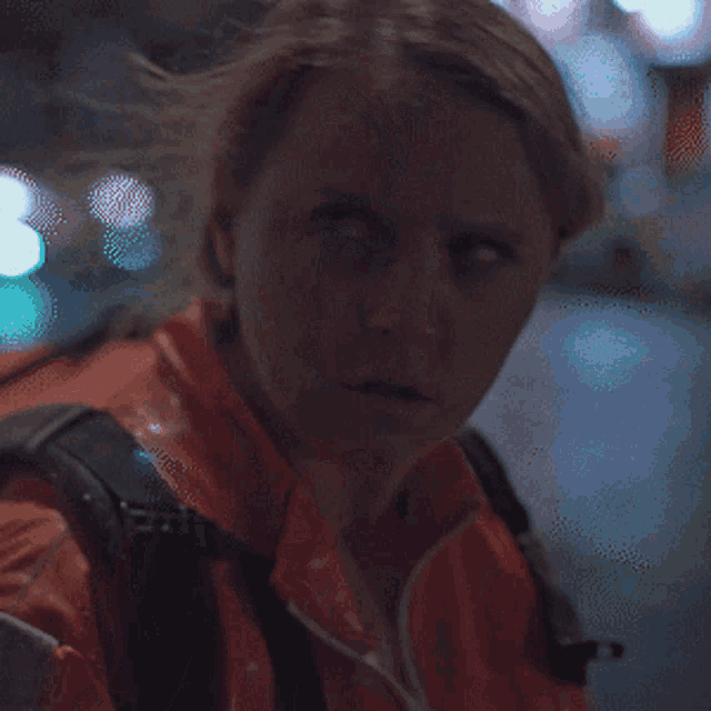 a woman with a backpack looks at the camera