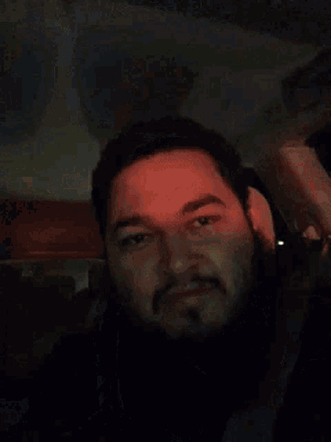 a man with a beard is sitting in a car with a seat belt on .