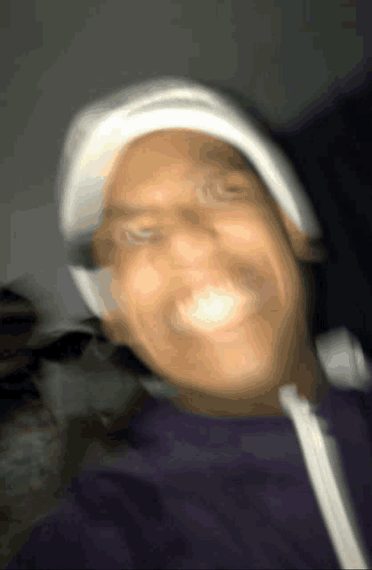 a blurry photo of a man wearing a white hat