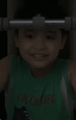a young boy wearing a green chuck life shirt