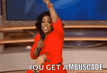 a woman in a red dress is holding a microphone and says " you get ambuscade "