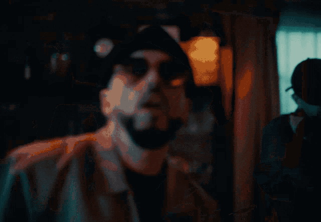 a man wearing sunglasses and a beanie making a funny face