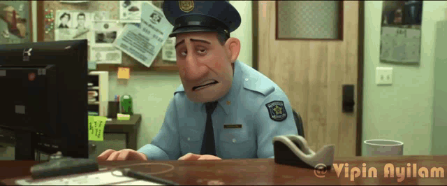 a police officer sitting at a desk in front of a computer screen