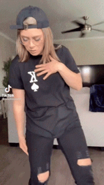 a woman wearing a hat and a black shirt with spades on it