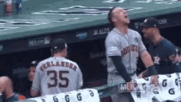 a baseball player wearing a jersey with the number 35 on it is standing in the dugout .