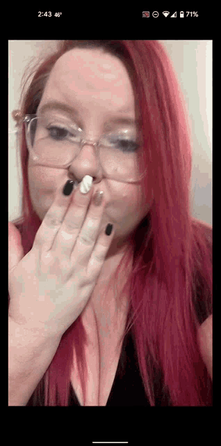 a woman with red hair is covering her mouth with her hand