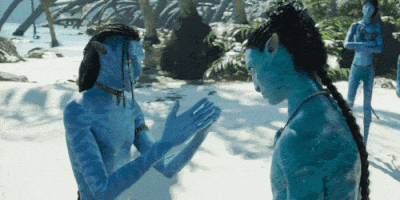 a couple of people with blue bodies are standing on a beach