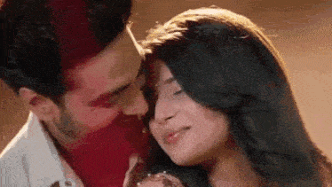 a man and a woman are kissing each other on the forehead .