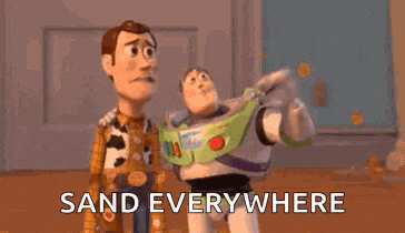 woody and buzz lightyear from toy story are standing next to each other and saying `` sand everywhere '' .