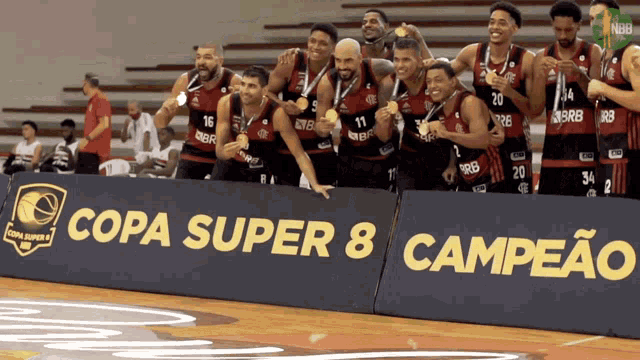 a group of basketball players standing in front of a sign that says copa super 8