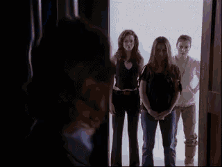 a group of people standing in a doorway looking at something