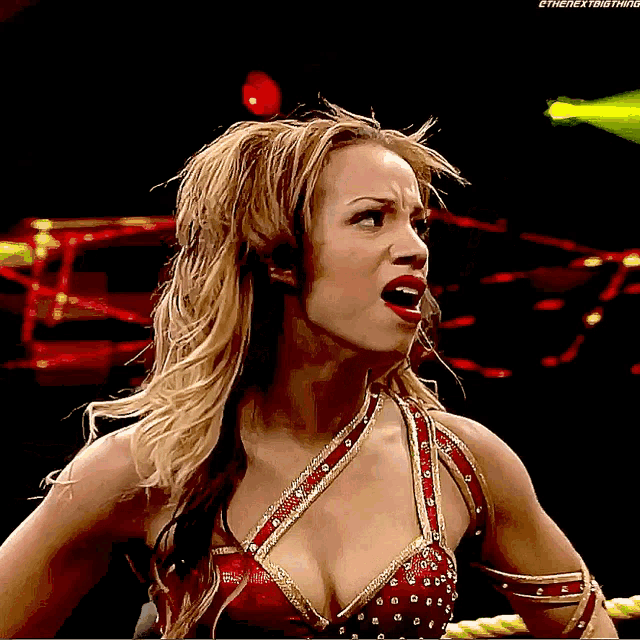 a woman in a red and gold outfit with the word ethe next thing on the bottom right