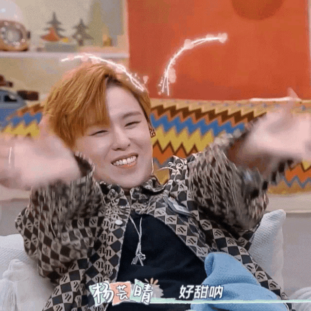 a person with chinese writing on their shirt is smiling with their arms outstretched