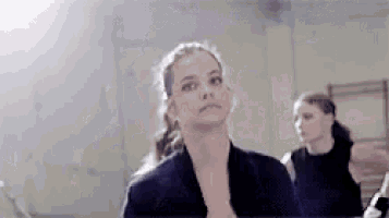 a woman in a black jacket looks up at the sky
