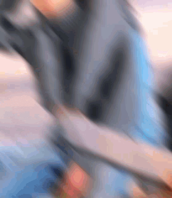 a blurred image of a person 's arm with a blue shirt