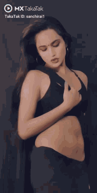 a woman in a black crop top is dancing in a video that says mx takatak