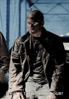 a man in a muddy jacket is standing next to a car and asking what is the soup de jour .
