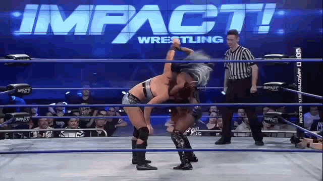 two women are wrestling in a ring with the words impact wrestling on the wall behind them