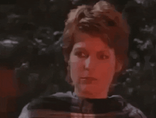 a close up of a woman 's face with a red light coming out of her eyes .